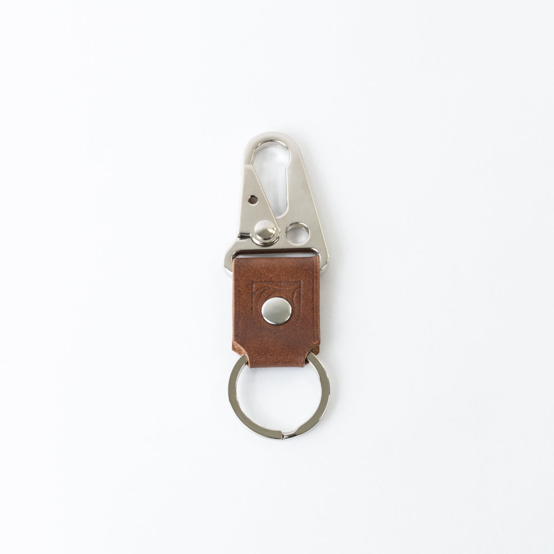 Brown leather keychain with metal clip on a white background
